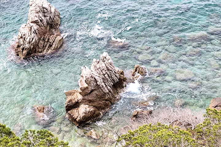 La crique de Sa Caleta avec ses bateaux colorés au pied du Castell d'en Plaja