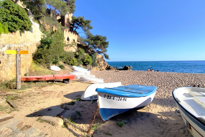 La crique de Sa Caleta avec ses bateaux colorés au pied du Castell d'en Plaja, Lloret de Mar